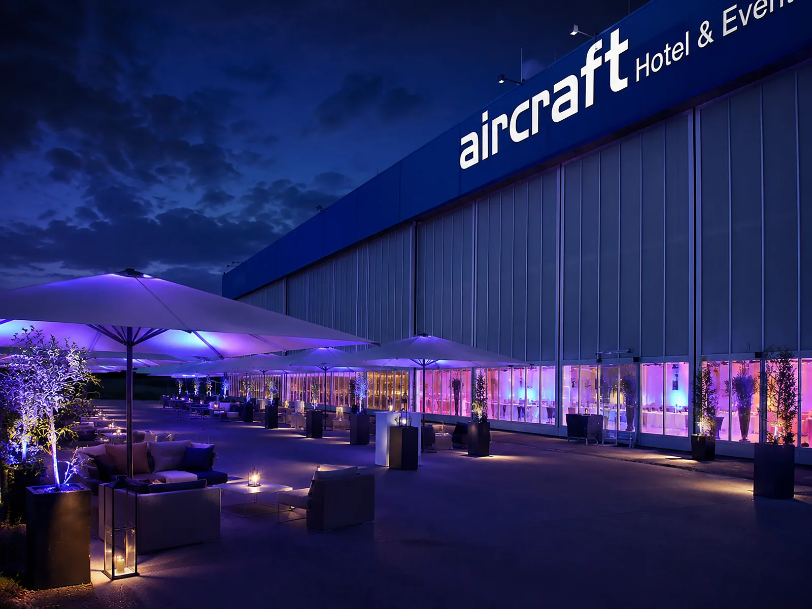 Freifläche vor dem Hangar mit Lounge-Möbeln in der Abenddämmerung