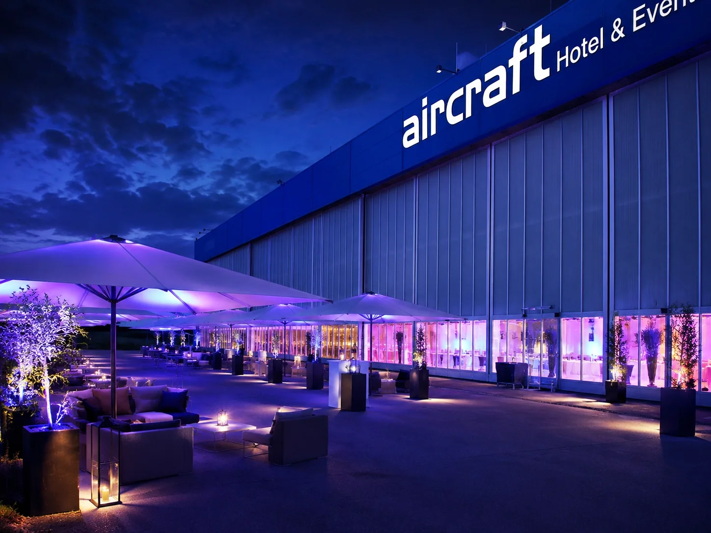 Freifläche vor dem Hangar mit Lounge-Möbeln bei Nacht