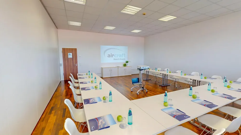 Moderner Tagungsraum in U-Form-Bestuhlung mit Praesentationsleinwand