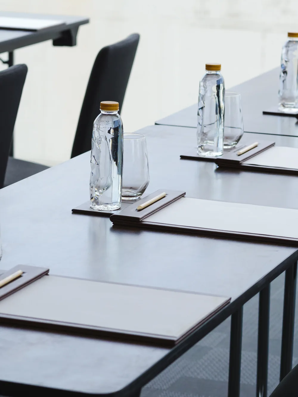 Professionell eingedeckter Seminarraum mit Wasserflaschen und Notizmappen